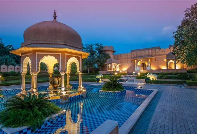 "Oberoi Rajvilas: Luxurious resort with beautiful gardens and traditional architecture."